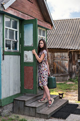 a rural young teacher with a suitcase walks through the doors of an old, shabby village school in...