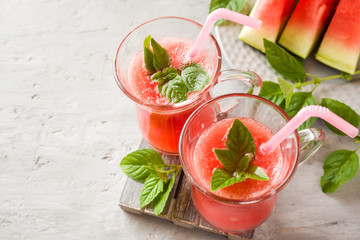 Fresh watermelon smoothie with ice and mint leaves in glasses. opy space