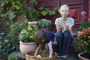 Girls sitting among flowerpots on front stoop