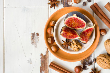 Fig walnuts cinnamon anise on a plate of old wooden background. copy space