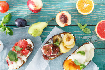 Different bruschetta fruit wooden table top view