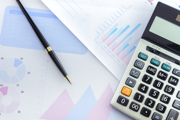 Calculator and Pen with Business Graphs finance document.	