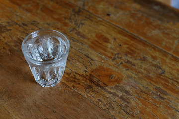 High angle view of a glass of cold water on a wooden table