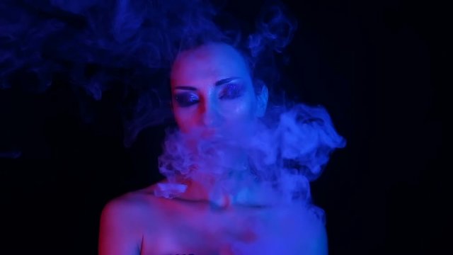 Exhalation of smoke. Vape Party, Nightlife. Beautiful Sexy Woman vaping electronic cigarette