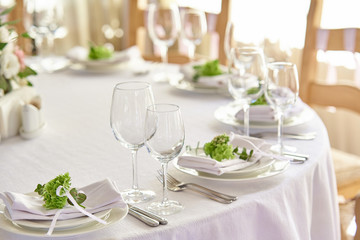  beautifully decorated festive table with plates and glasses and a bouquet of flowers in a restaurant