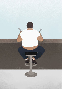 Overweight man eating at diner counter