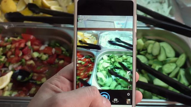 Taking pictures of food with a cell phone.
