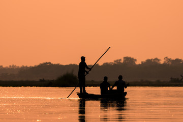 Men in a boat on a river silhouette