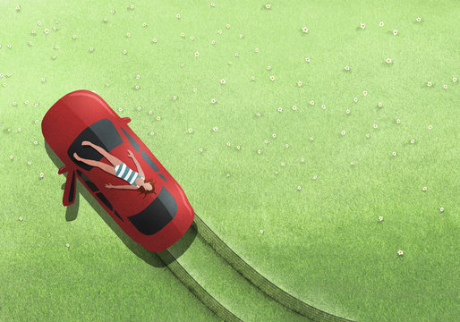 Woman in bathing suit sunbathing on top of car in grassy field