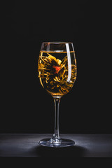 glass of chinese flowering tea on table isolated on black