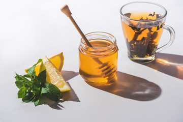 healthy tea with lemon, mint and honey on white tabletop
