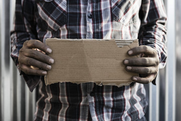 Homeless man holding cardboard sign
