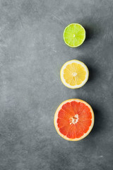 Slices of Cut in Half Organic Citrus Fruits Grapefruit Lemon Lime on Dark Stone Background. Imitation of Stop Lights. Superfoods Antioxidants Vitamins Healthy Diet Concept. Flat Lay