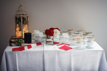 Coffee, tea and cups on a table with white tablecloth
