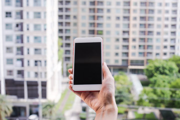 hand hold smartphone with city background