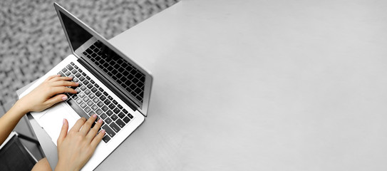 Website heading and banner of laptop with female typing hands, copy space in grey color. Concept of...