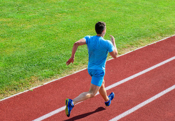 Obraz premium Runner sporty shape in motion. Athlete run stadium green grass background. Life non stop motion. Sport lifestyle and health concept. Man athlete run to achieve great result. Impulse to move