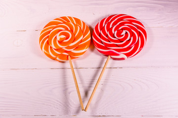 Two round lollipops on a wooden table. Top view