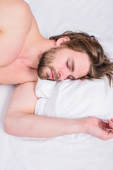 Obraz na płótnie Canvas Pleasant awakening concept. Man unshaven handsome guy naked torso relaxing bed top view. Guy sexy macho lay white bedclothes. Man sleepy drowsy bearded face having rest. Guy sleepy morning nap