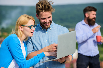 Colleagues working laptop, boss smoking while coffee break on background. Colleagues with laptop...