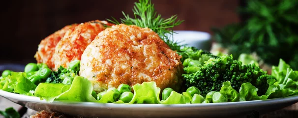 Photo sur Plexiglas Plats de repas Fish cutlets or meatballs from cod and pike perch with a garnish of green peas and broccoli, rustic style, selective focus