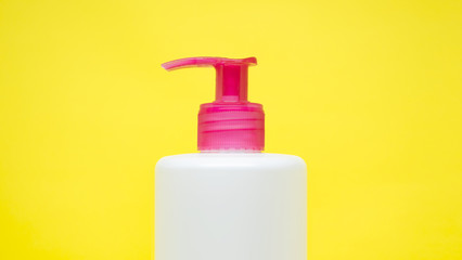 Blank white container with a red push cap isolated on a yellow background