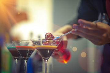 bottle of fruit cocktail pour into a cocktail glass by bartender for mixing make cocktail party funny enjoy and outdoor entertainment