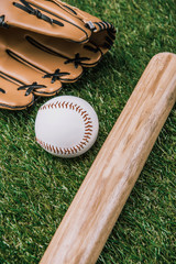 close up view of baseball equipment arranged on green grass