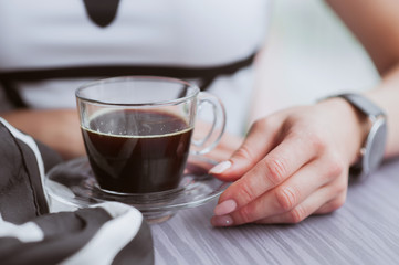 Woman's hands with a cup of coffe in the cafe