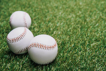 close up view of white baseball balls on green lawn