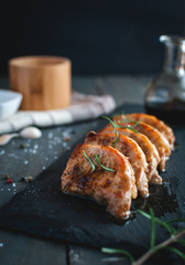 Close-up of roasted pork chops with fresh rosemary on dark background