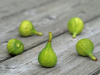 five little green figs on wooden background