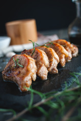 Close-up of roasted pork chops with fresh rosemary on dark background