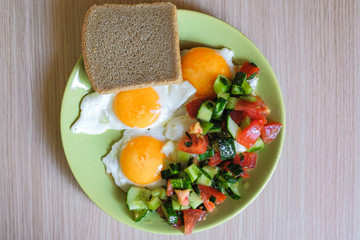 delicious fried chicken eggs with salad and bread on a plate
