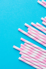 Obraz premium Bunch of Elegant White Pink Striped Paper Drinking Straws on Mint Blue Background. Birthday Party Babyshower Invitation Card Fun Kids Holiday Celebration Concept