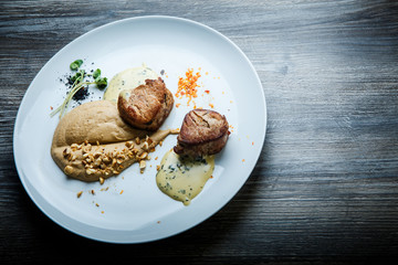 top view on two tasty pieces of grilled meat with puree and sauce