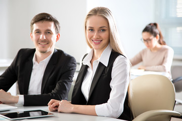 Young business people smiling looking at camera