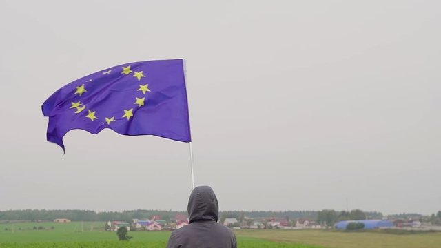 Man waving a flag of the European Union in winter on a ski slope