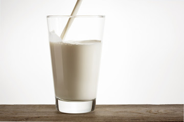 Fresh natural milk is poured into a glass.