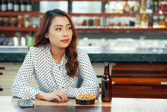 Young attractive business woman spending time in bar on friday night