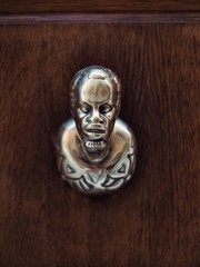 Fototapeta na wymiar Gold door handle in the form of a human head in Venice
