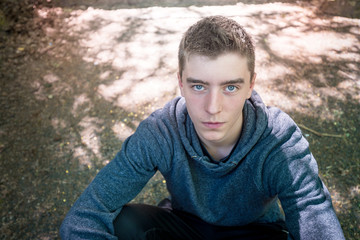portrait of a young man sitting in the dirt