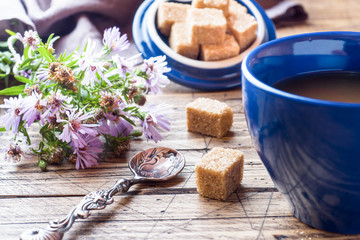 Cup of hot steaming black coffee with sugar cubes on wooden tabl