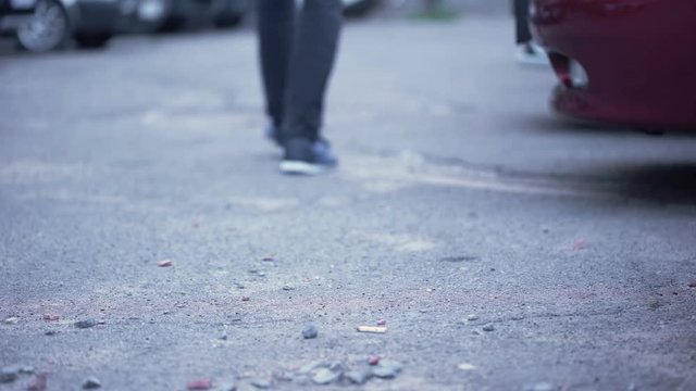 Male throwing smoking cigarette walking on street, dirty city, garbage pollution