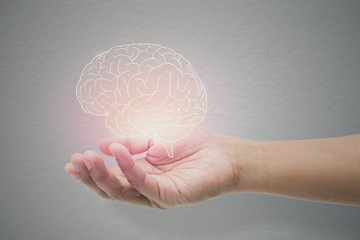 Man holding brain illustration against gray wall background. Concept with mental health protection...