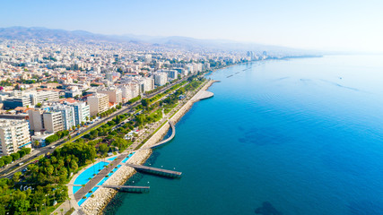 Luchtfoto van Molos Promenade park aan de kust van het stadscentrum van Limassol, Cyprus. Vogelperspectief van de steiger, wandelpad aan het strand, palmbomen, Middellandse Zee, pieren, stedelijke skyline en haven van bovenaf
