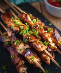 Close-up of homemade honey and beer BBQ chicken skewers with fresh parsley