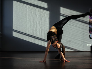 A young girl is engaged in jazz modern dance in the hall.