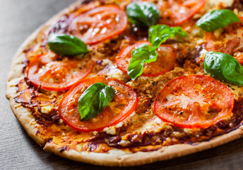 Pizza with Mozzarella cheese, Tomatoes, pepper, Spices and Fresh Basil. Italian pizza. Pizza Margherita or Margarita. on wooden background