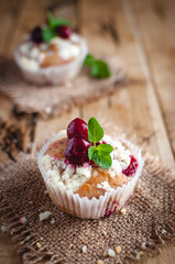 Close-up of cherry muffin with crumbly topping on wooden background 
